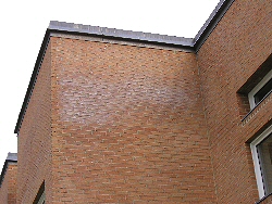 Billedet viser et hus af rde mursten, hvor der er en misfarvning af murstenene