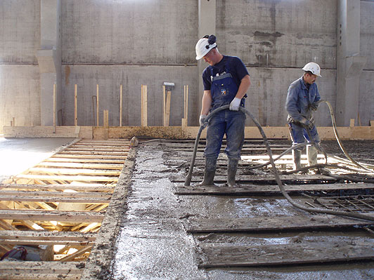 Et par betonarbejdere vibrerer et traditionelt betongulv med en stavvibrator. Arbejdsstillingen er ubekvem og ofte direkte skadelig for ryg og lnd. Arbejderne udsttes samtidig for stj og vibrationer. Denne arbejdstype bortfalder ved anvendelse af SCC.