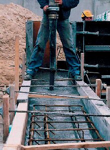 Billedet viser en mand i frd med at udstbe beton