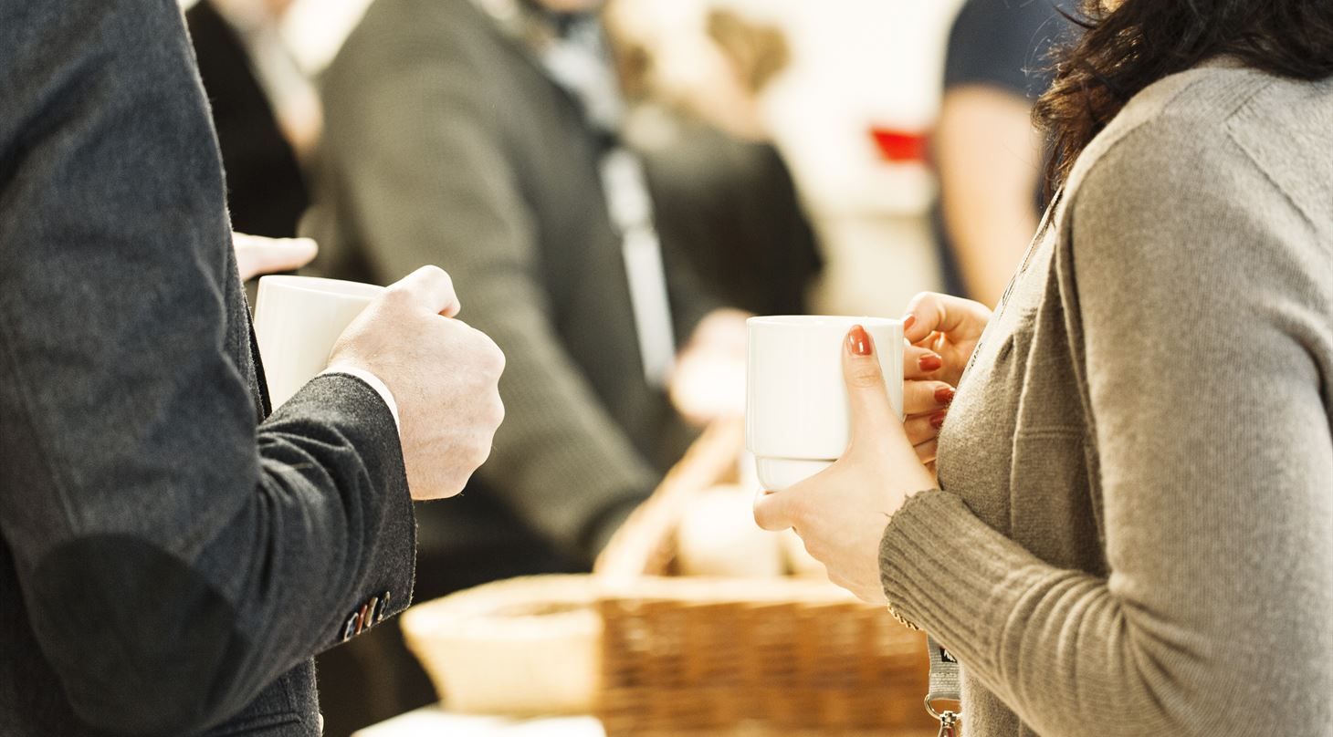 to personer står med en kop kaffe