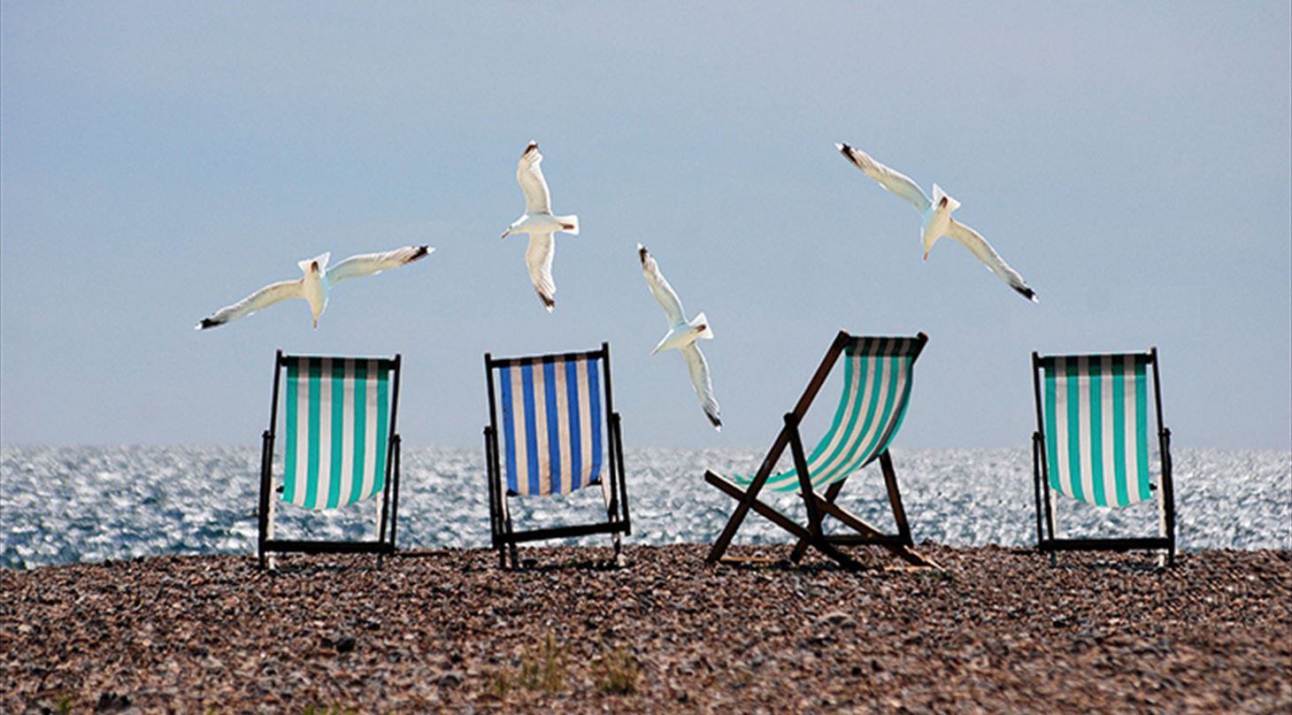 Fire liggestole på en strand