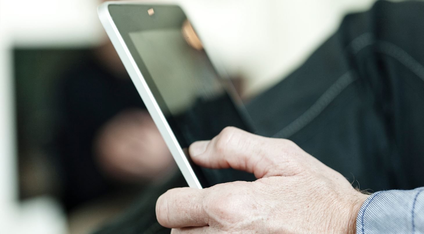 Mand sidder med tablet