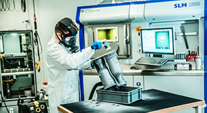 Mand med 3D-printet raketdyse foran printer