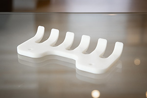 Hvid robotgriber i nylon på glasbord