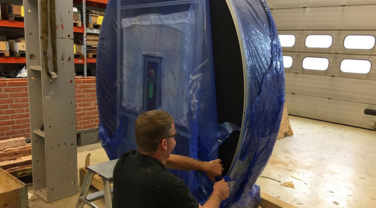 mand ved at pakke maskine ud af bl�t plast