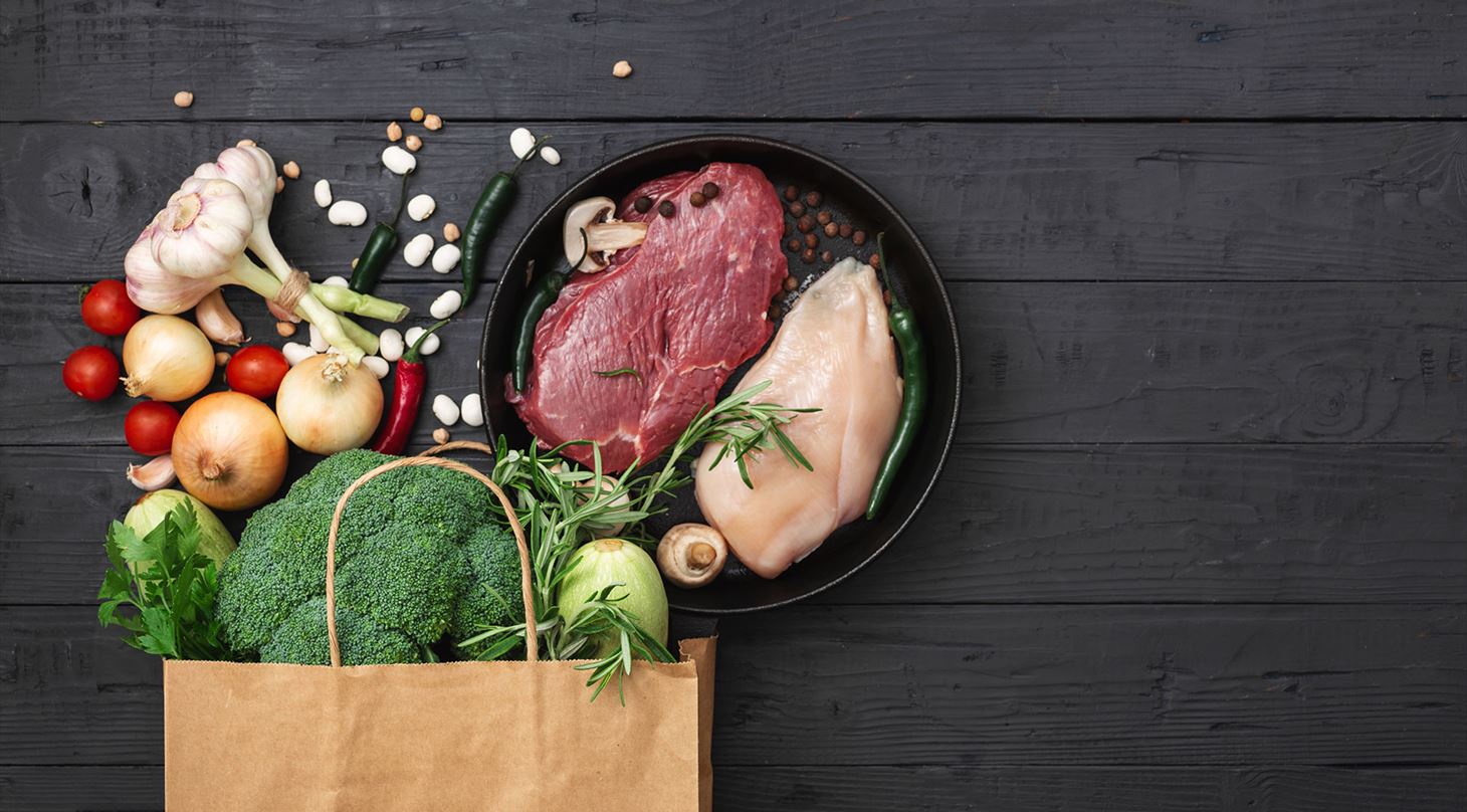 Kød og grøntsager pakket ud fra en supermarkedspose i brunt papir