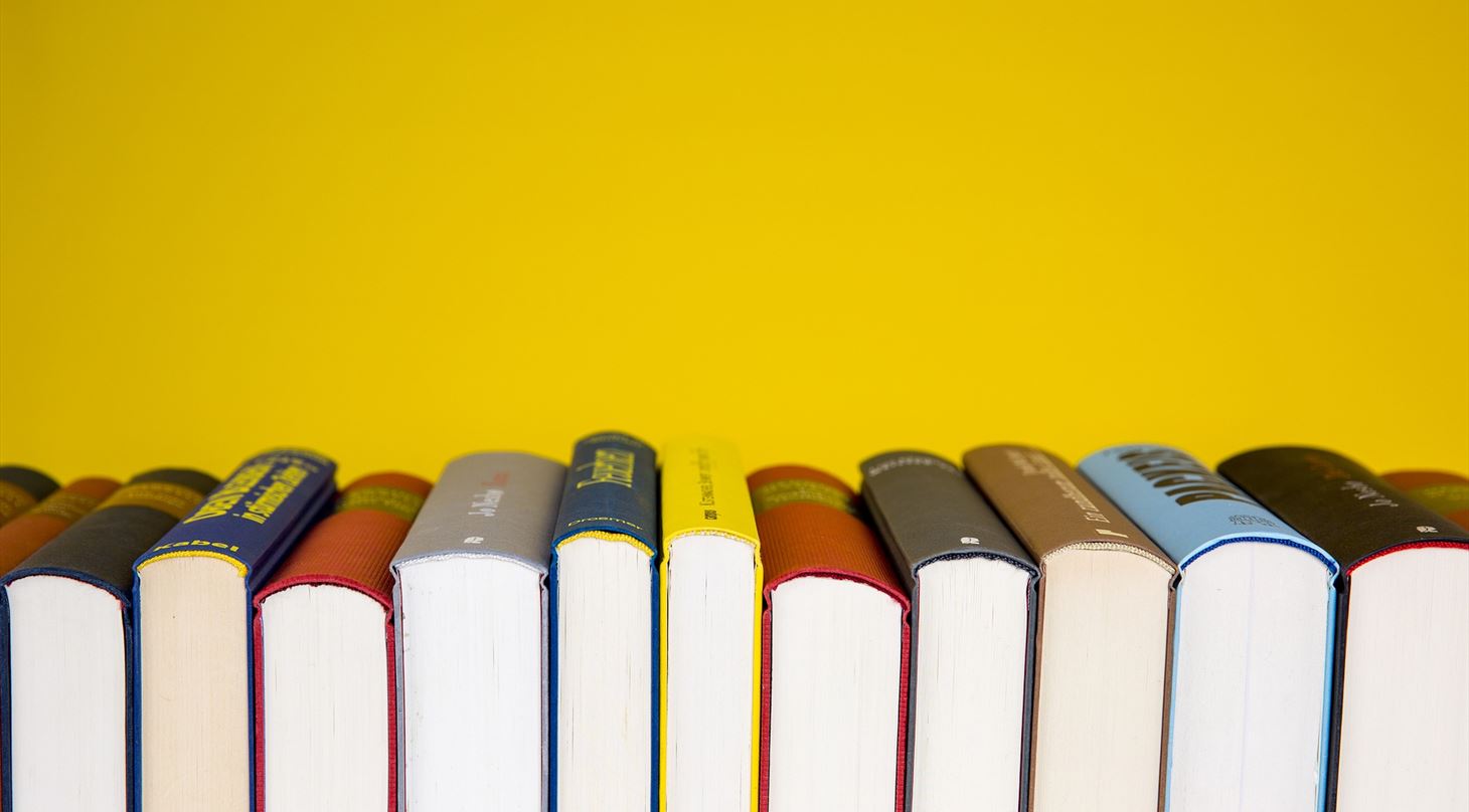 Billede af en række bøger på gul baggrund