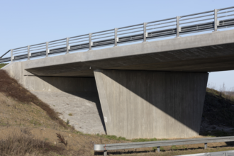 Den ene ende af en motorvejsbro stbt i beton.