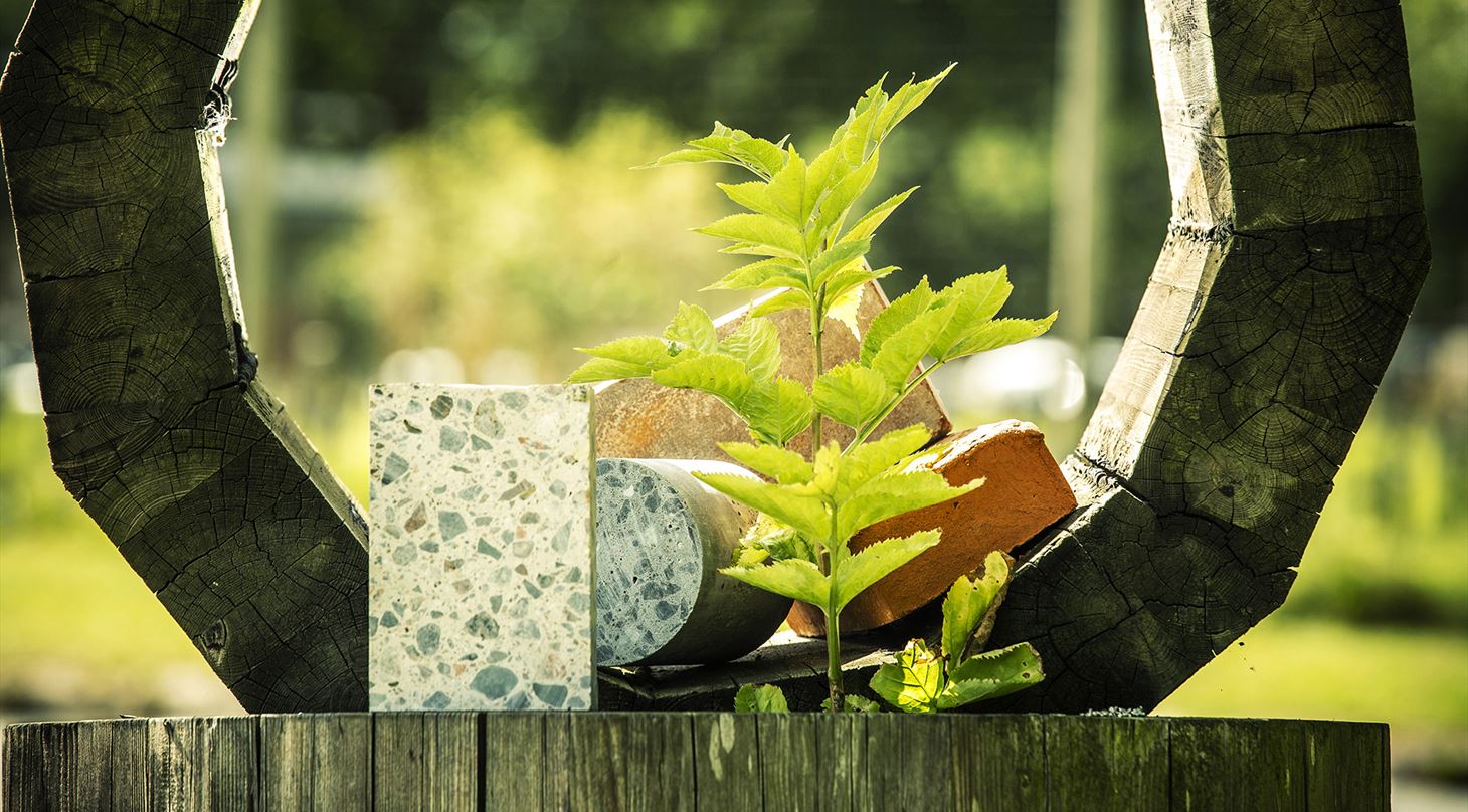 Et hjul af tr med nogle byggematerialer og en plante i midten