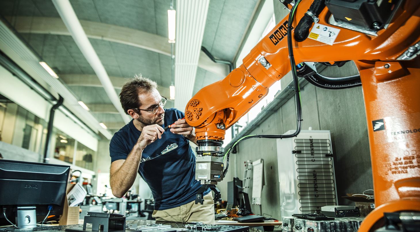 Teknisk medarbejder i frd med at arbejde p en robot.