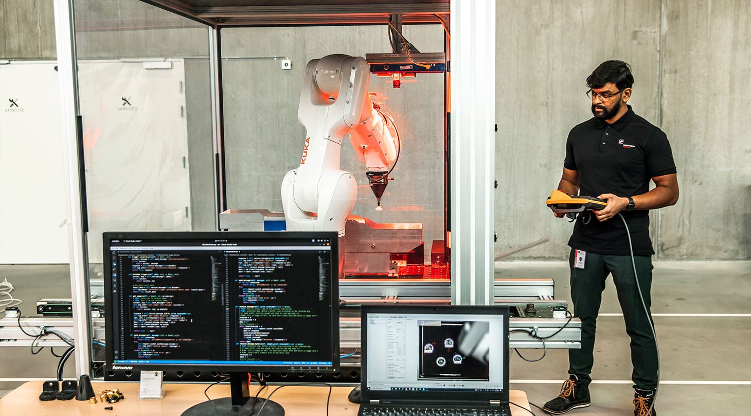Ansat ved Teknologisk Institut programmerer en robot, som gr brug af AI