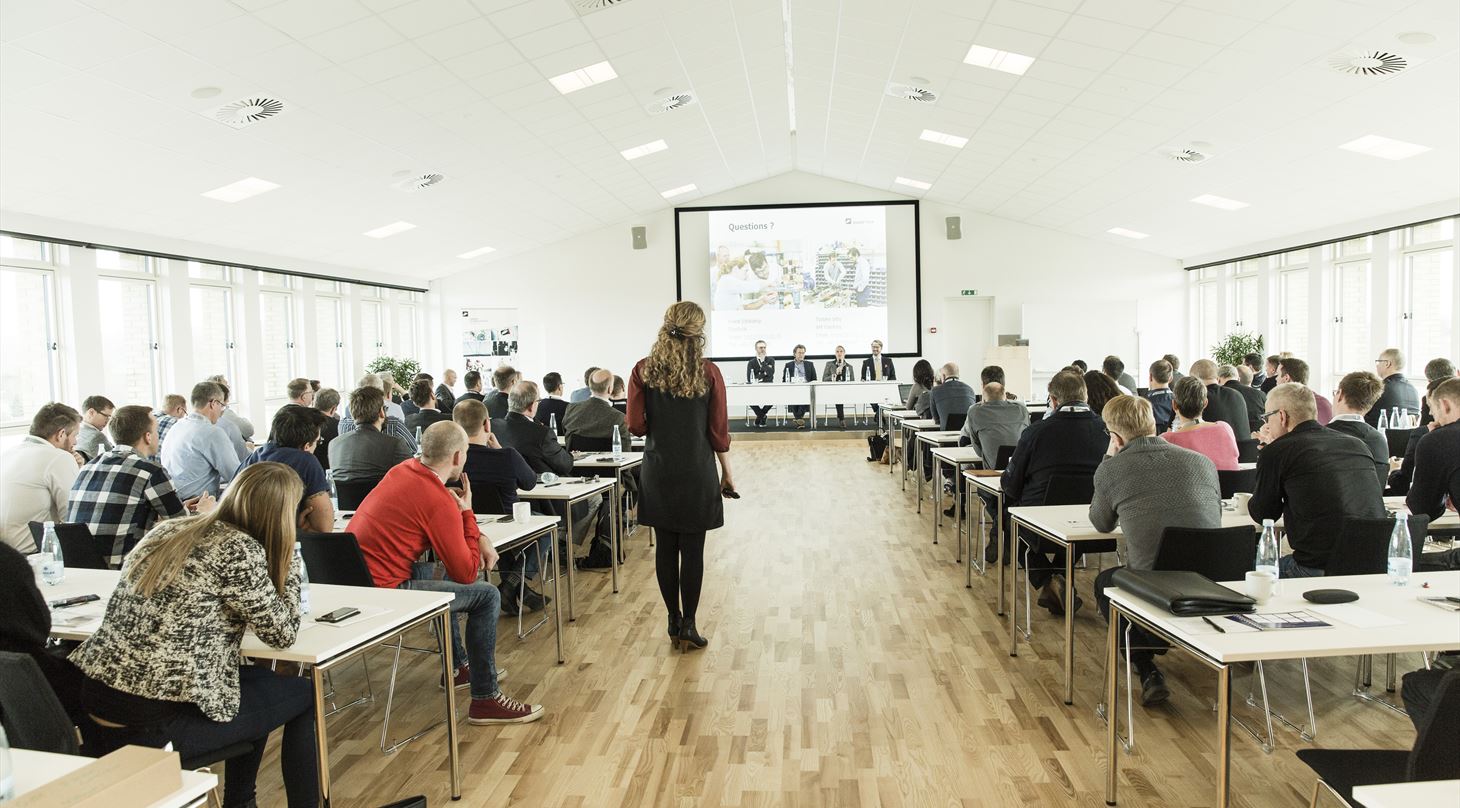 Billede af konferencesal fyldt med mennekser