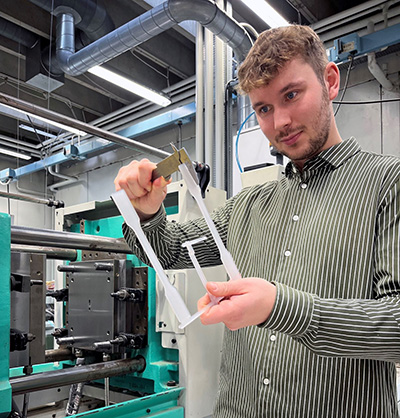 Billedet viser en test-situation i laboratoriet. P billedet str MVES med en prve foran et testapparat. Billedet m KUN bruges efter accept fra MVES og Plast og Emballage. Billedet er brugt i Plast og Emballages Medlemsinformation nr. 4-2024
