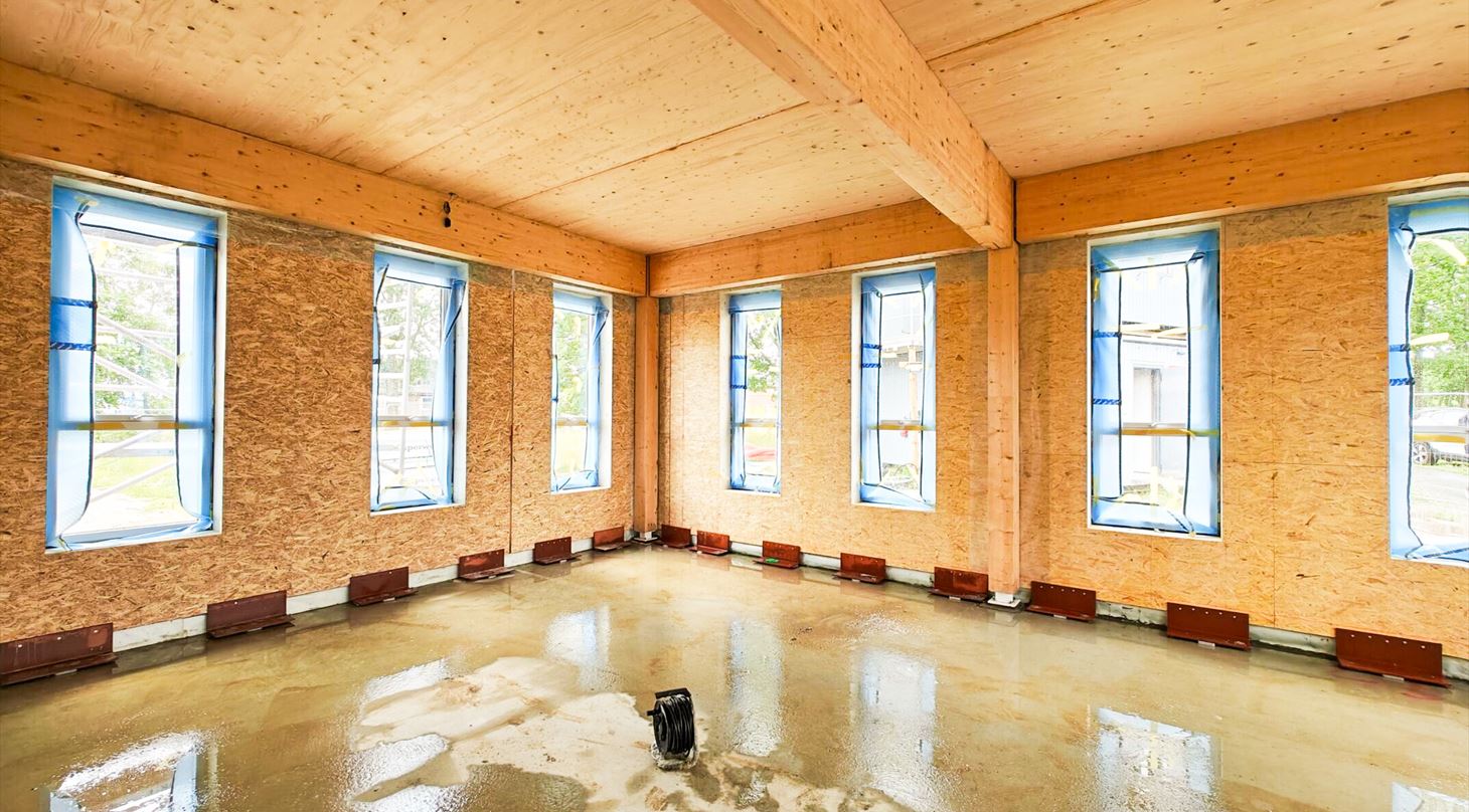 Wooden building under construction with wet floor.
