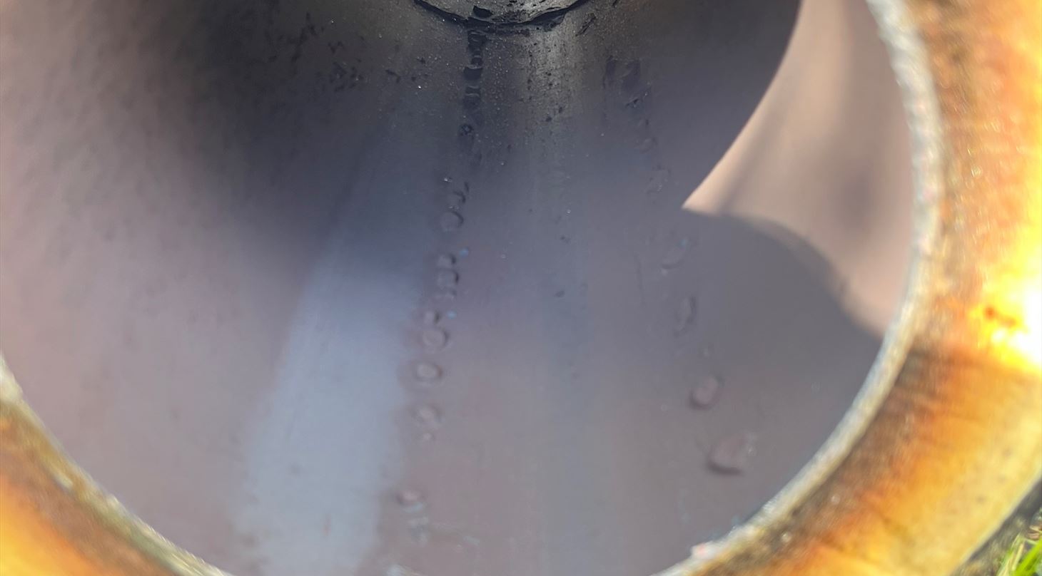 Fjernvarmer�r set indefra med begyndende korrosionsspor og fugt p� indersiden.