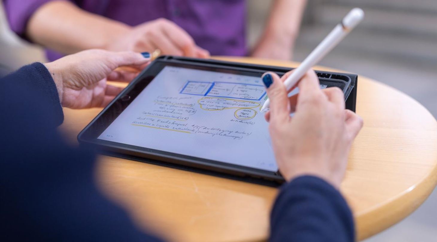 Ipad og hænder som tegner på skærmen