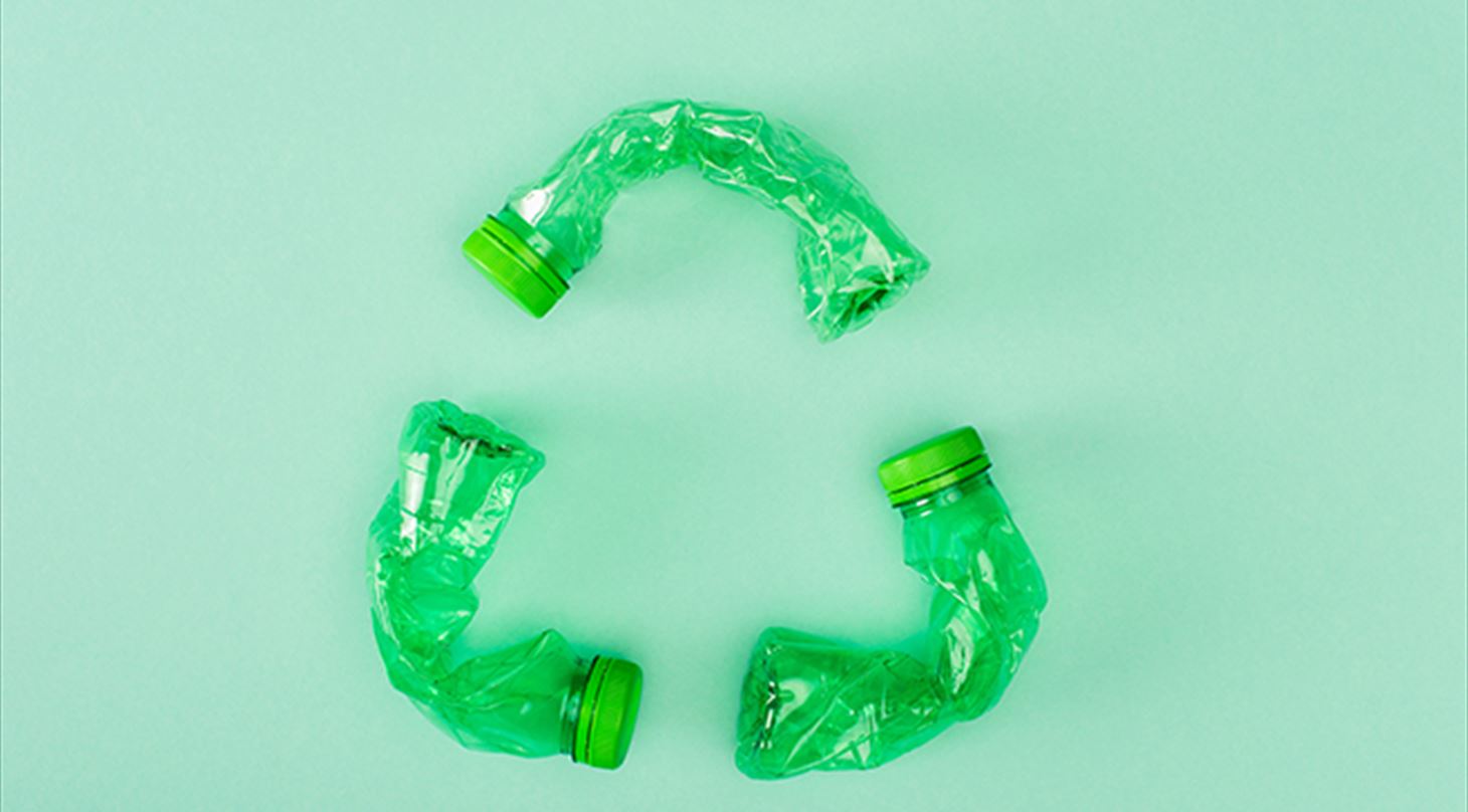 Billedet viser en genbrugstrekant af grnne plastflasker p en lysegrn baggrund. Billedet er fra Colourbox