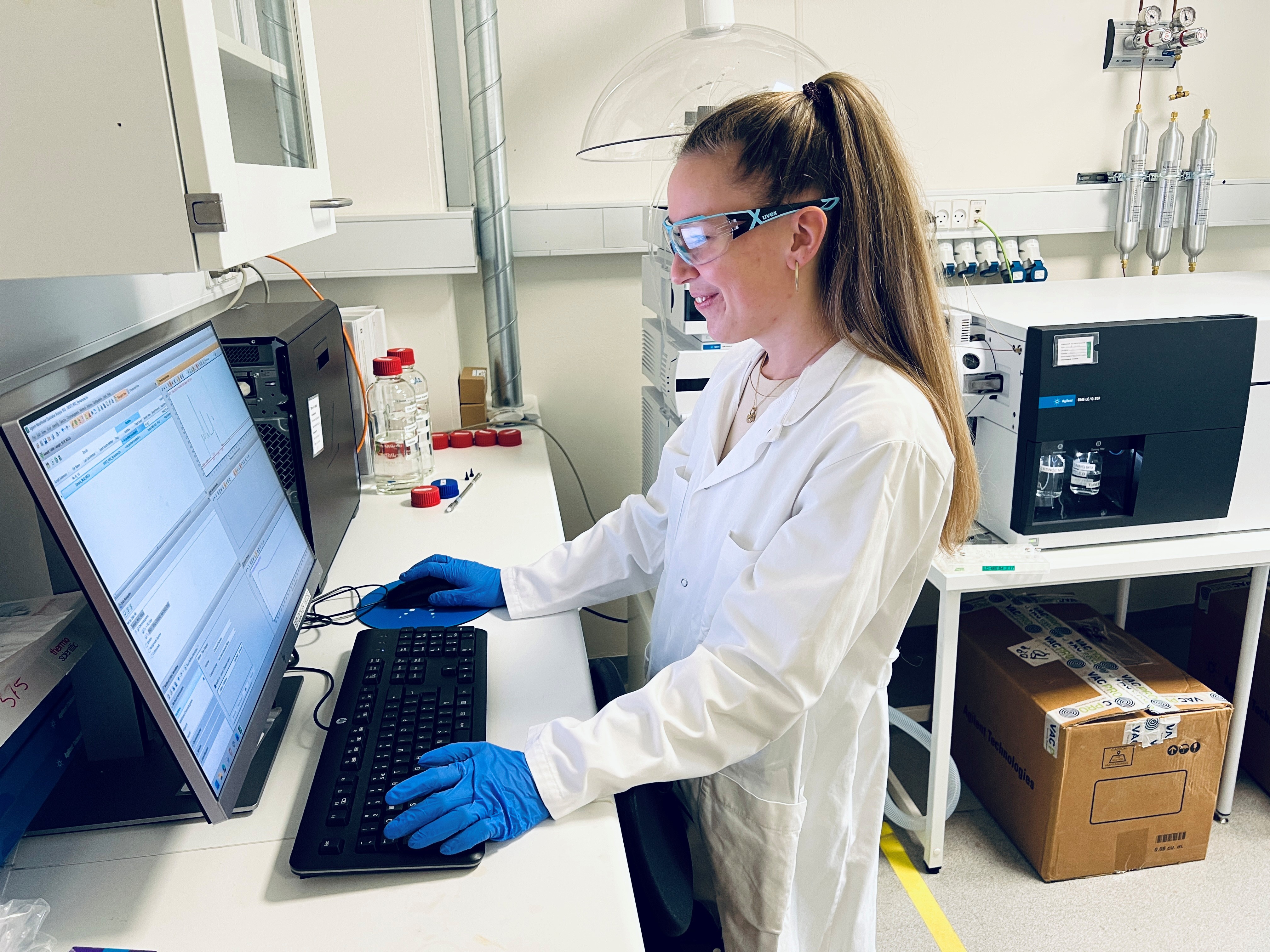 Laborant står for computerskærm og kigger på data i laboratoriet