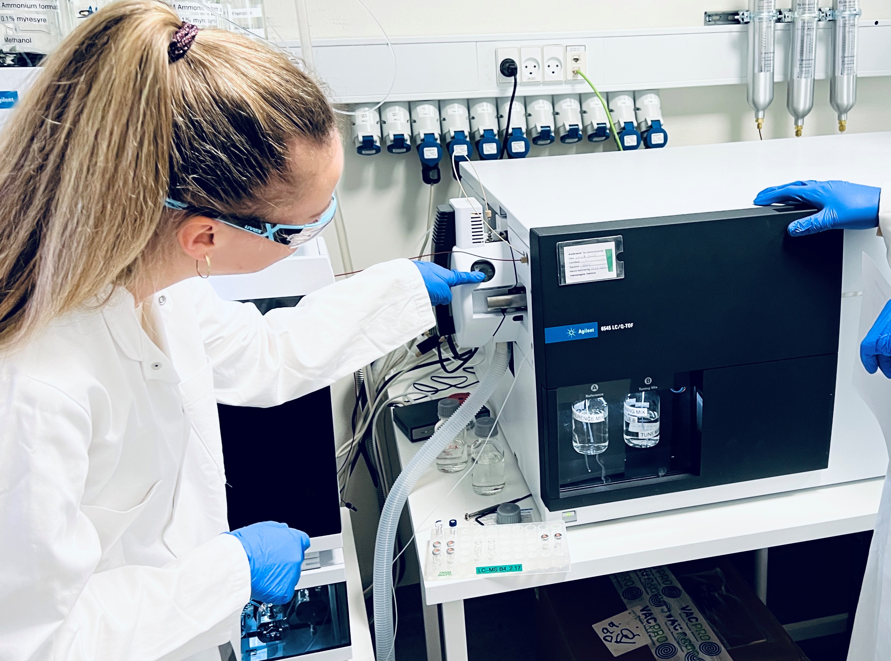 Maskiner i laboratorie og laboranter der rører ved dem