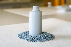 Hvid plastbeholder omgivet af plastpulver