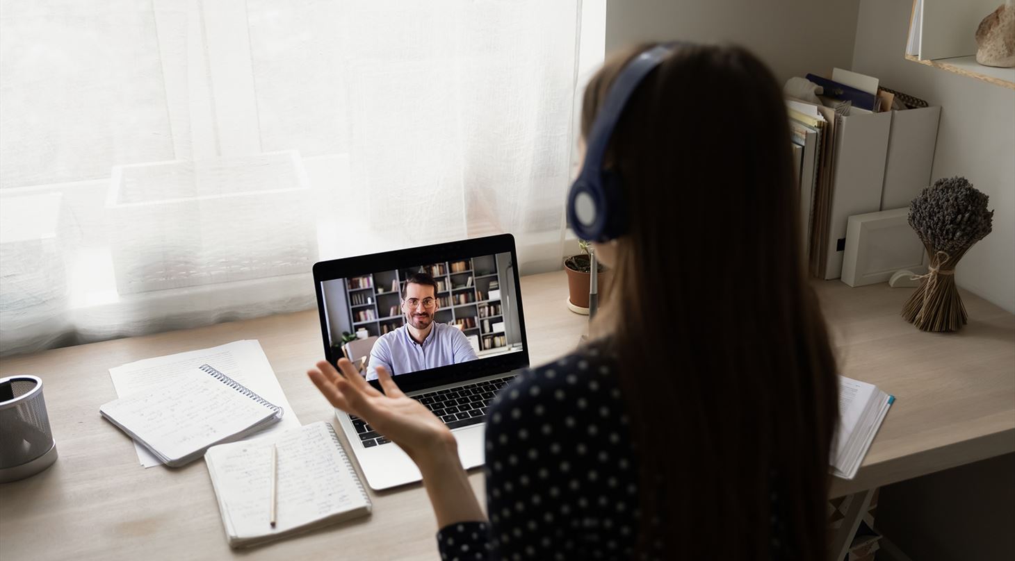 Kvinde deltager på et online kursus ved sit skrivebord